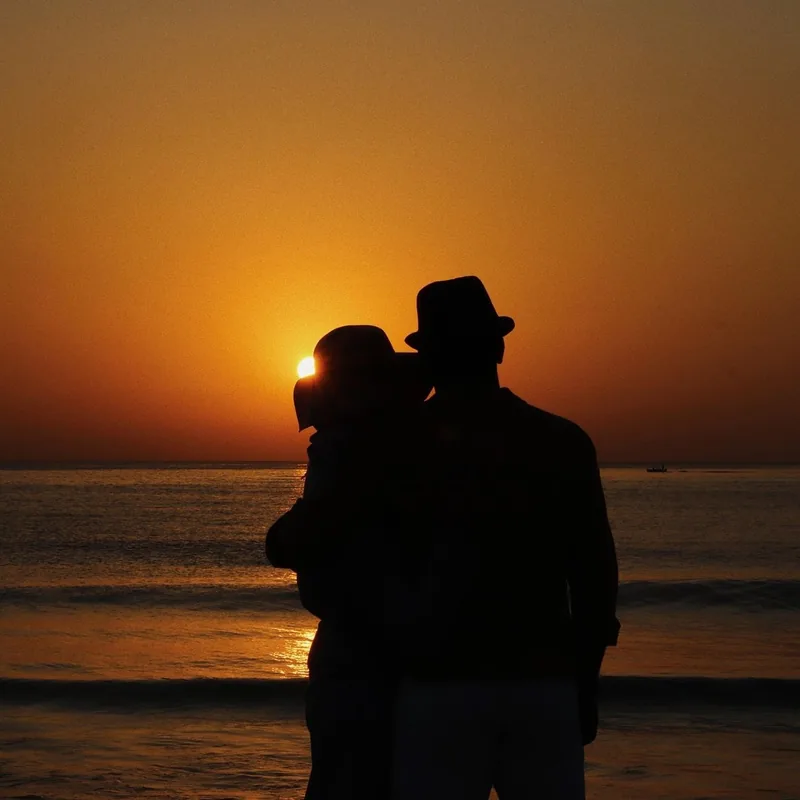 A couple watching the sunset together on a honeymoon getaway